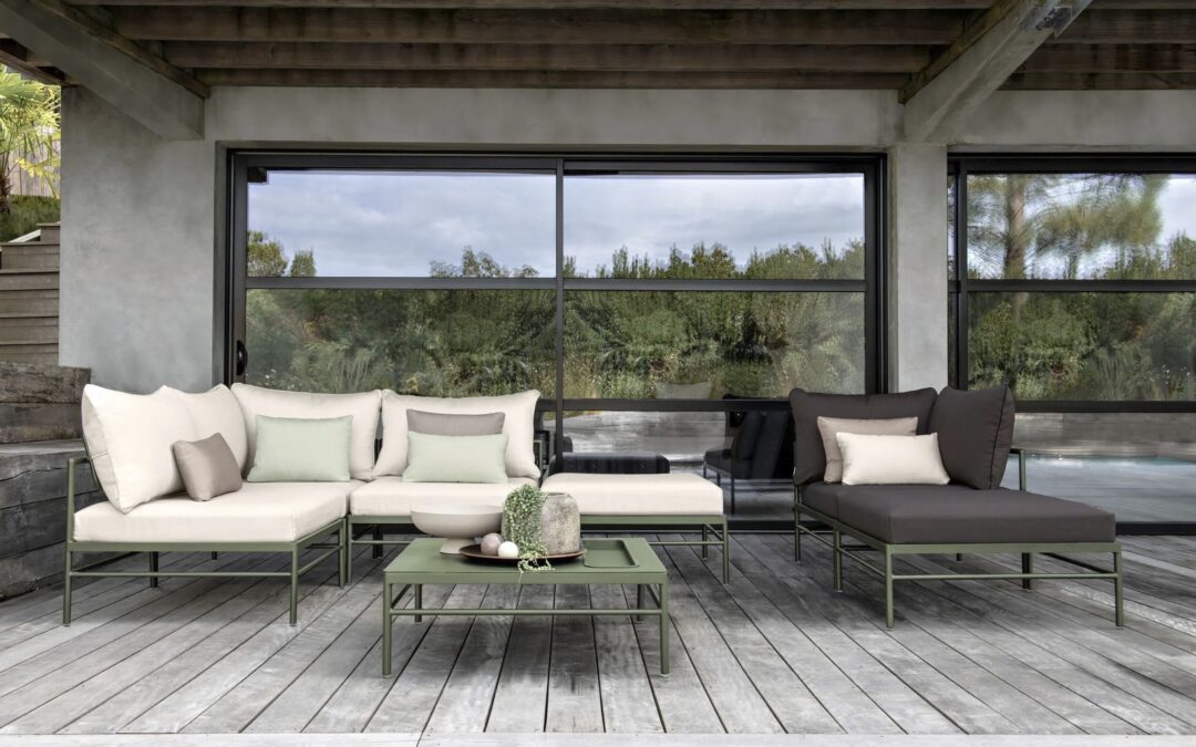Sofás modulares de exterior y mesa baja en un porche con suelo de madera